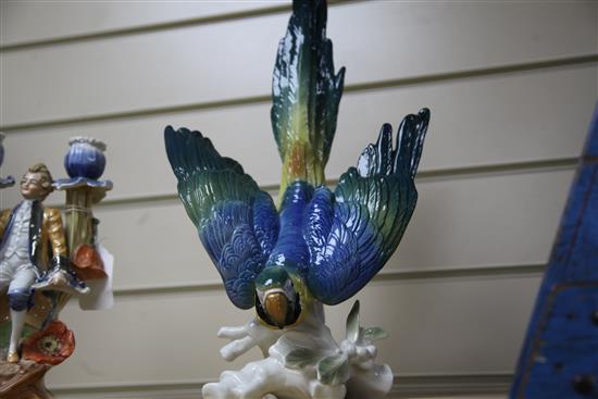 A Continental porcelain parrot and a two branch figural candelabrum